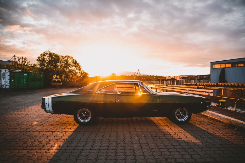 black coupe parked on brown brick floor during sunset