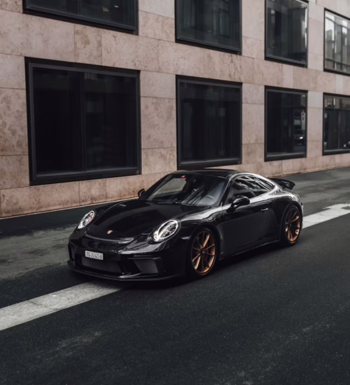 A lifted Lamborghini being loaded via hydraulic ramp onto an enclosed trailer — representing safe low-clearance car transport by Navi.